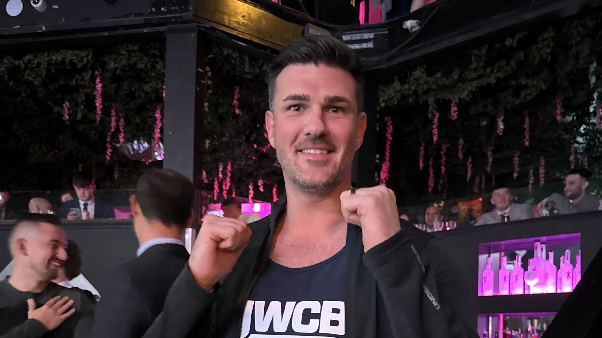 Mike Connolly smiling with his fists raised at the charity boxing event